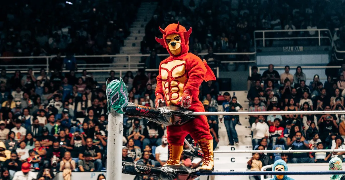 A vibrant luchador stands confidently in front of a cheering crowd at a lively wrestling event in Mexico.