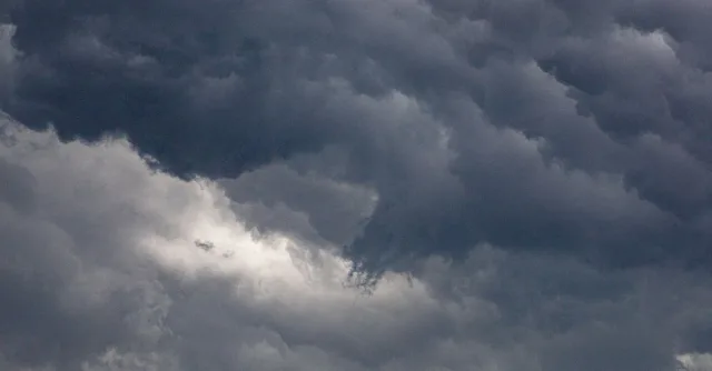 A captivating image of dense, dark clouds in a dramatic overcast sky, hinting at a storm.