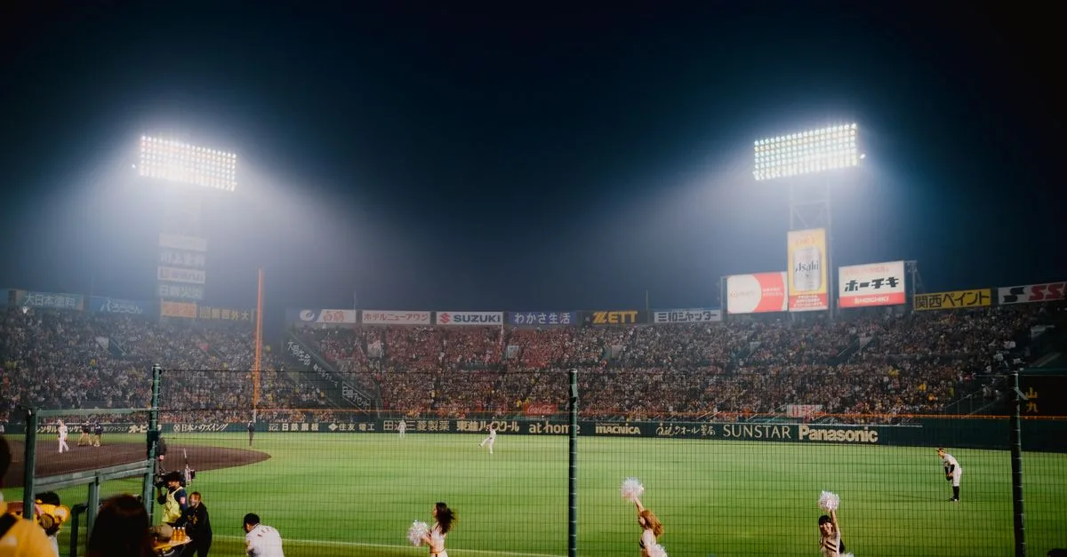 Thrilling night baseball game at Hanshin Koshien Stadium in Japan with vibrant crowd.