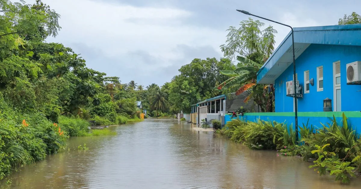 A tropical street in Nolhivaranfaru, Maldives, submerged due to flooding.