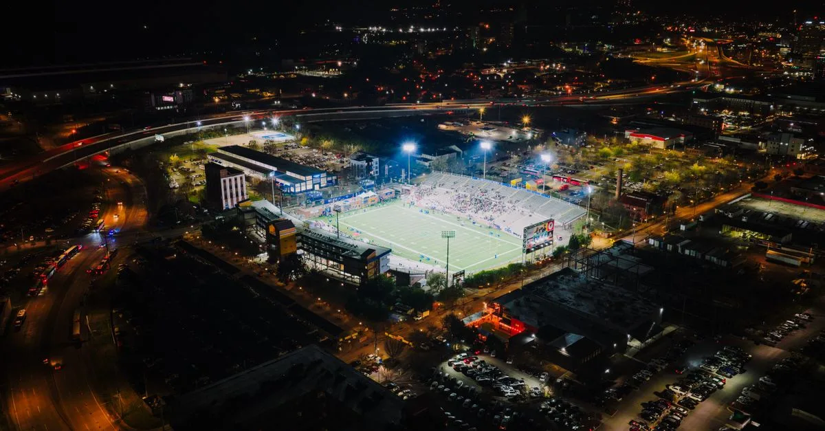 Aerial view of a lit-up football stadium during nighttime in Chattanooga, Tennessee.