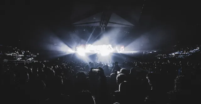 Dynamic concert scene with an energetic crowd at night in a London stadium.