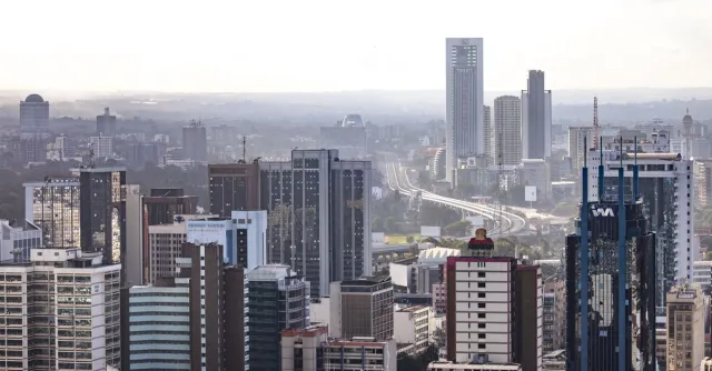 Aerial view of Nairobi's modern skyscrapers and bustling urban landscape under a clear sky.