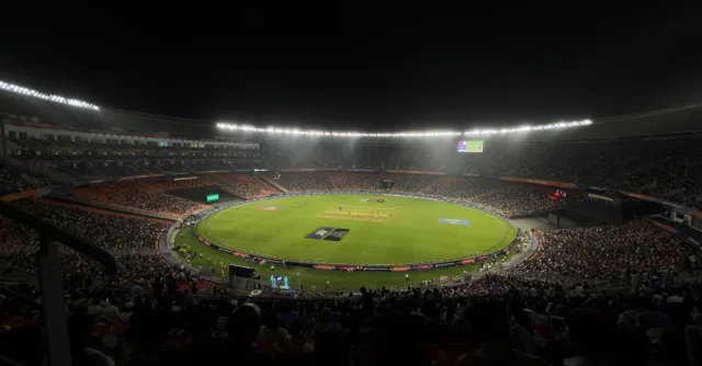 A captivating night cricket match with a large crowd at Narendra Modi Stadium in Ahmedabad, India.