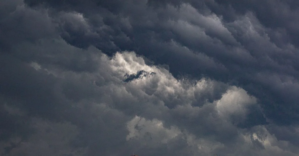 Dark dramatic clouds gathering over urban buildings, hinting at an approaching storm.
