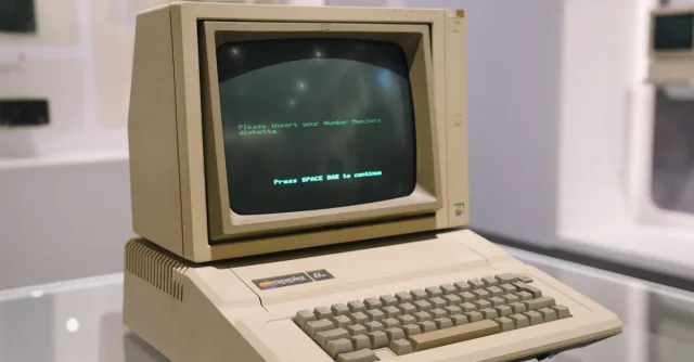 Retro Apple II computer in a museum setting, showcasing vintage technology design.