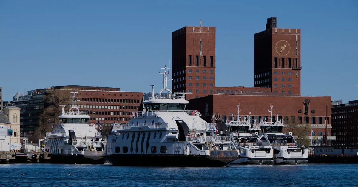 Ferries and Oslo City Hall under a clear blue sky. Perfect urban waterfront scene.