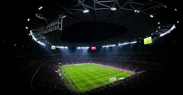 Aerial view of a night football match in Budapest. Illuminated stadium full of fans adds dramatic atmosphere.