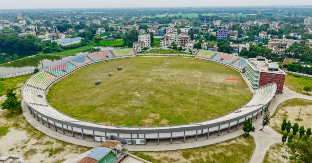 Aerial view of an expansive football stadium with surrounding cityscape