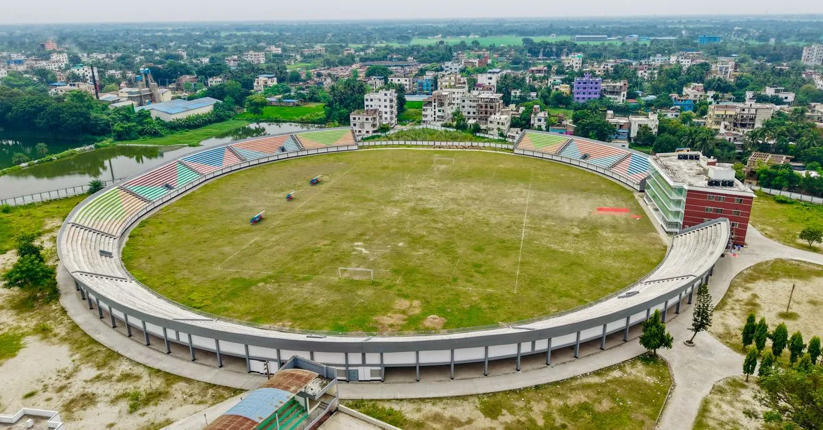 Aerial view of an expansive football stadium with surrounding cityscape