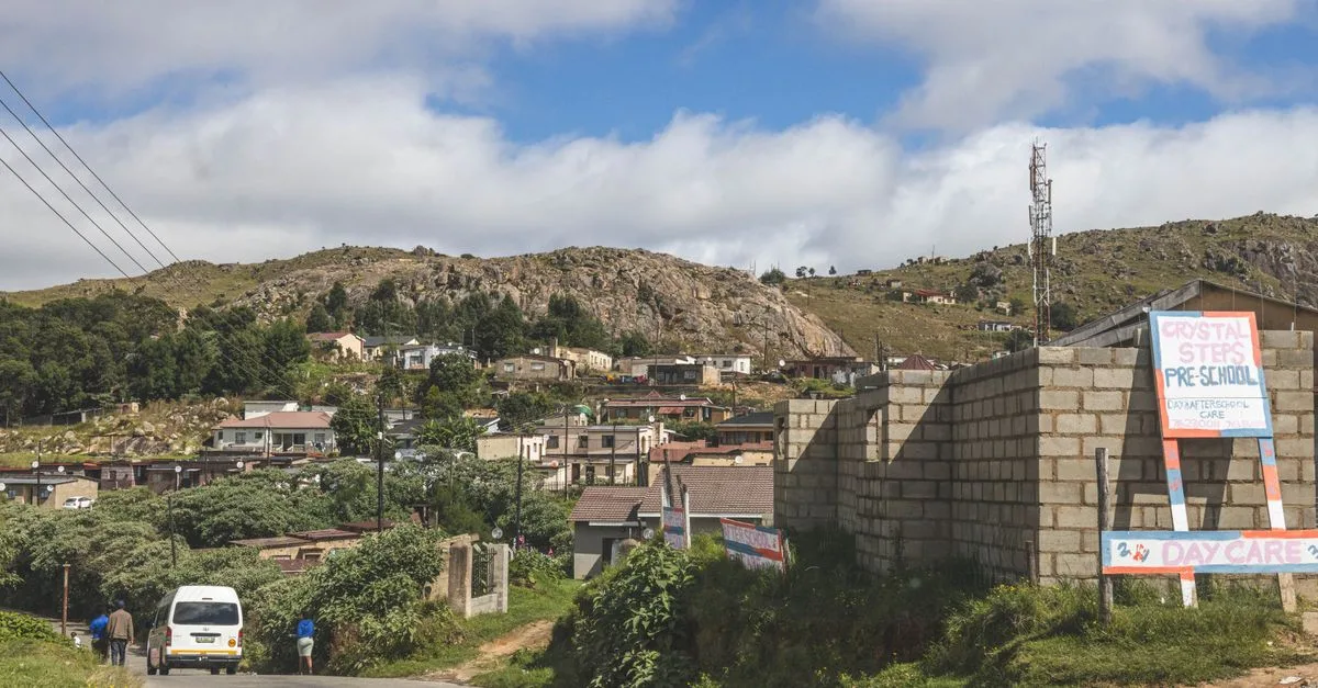 A picturesque view of a village in the mountainous region of Eswatini with clear blue skies.
