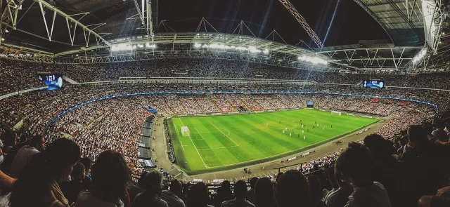 A soccer stadium illuminated under floodlights for an international football match.