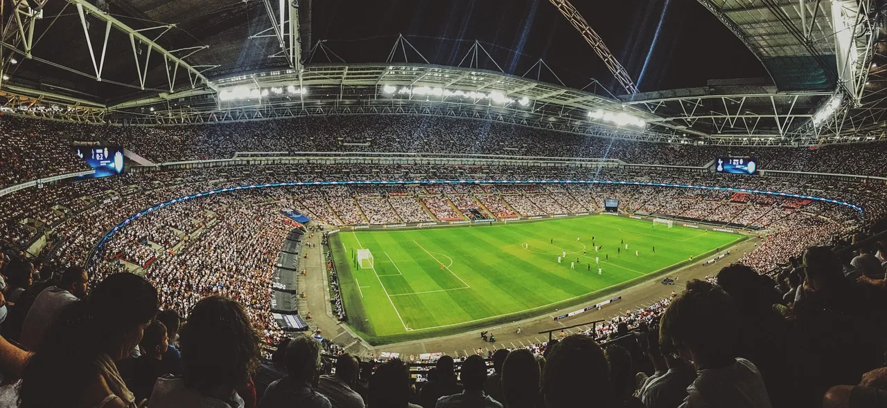 A soccer stadium illuminated under floodlights for an international football match.