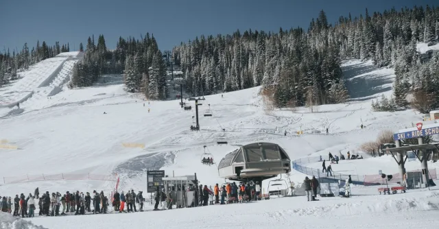 Skiers enjoying a snowy winter day at a Colorado ski resort with chairlifts and ski slopes.