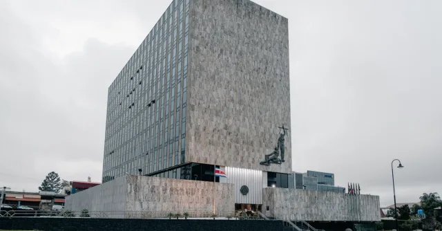 Architectural photo of the Supreme Court building in San José, Costa Rica featuring modern design and national flags.