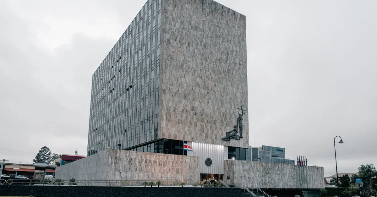 Architectural photo of the Supreme Court building in San José, Costa Rica featuring modern design and national flags.