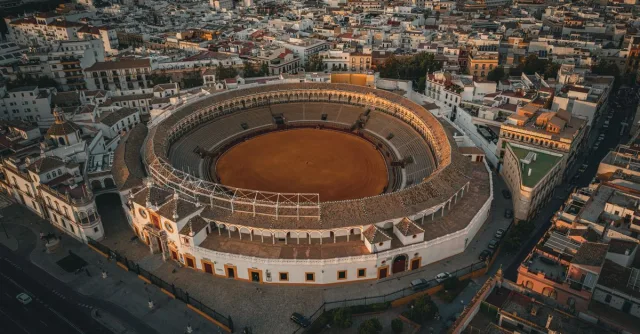Stunning drone shot of Plaza de Toros de la Maestranza amid Seville's urban landscape.