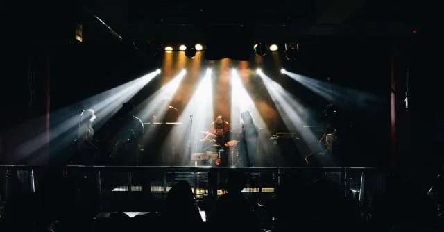 A vibrant live music concert in Lima, Peru, featuring musicians on stage with dramatic lighting.