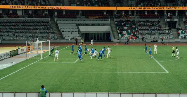 A thrilling football game captured in a large, modern stadium at night.