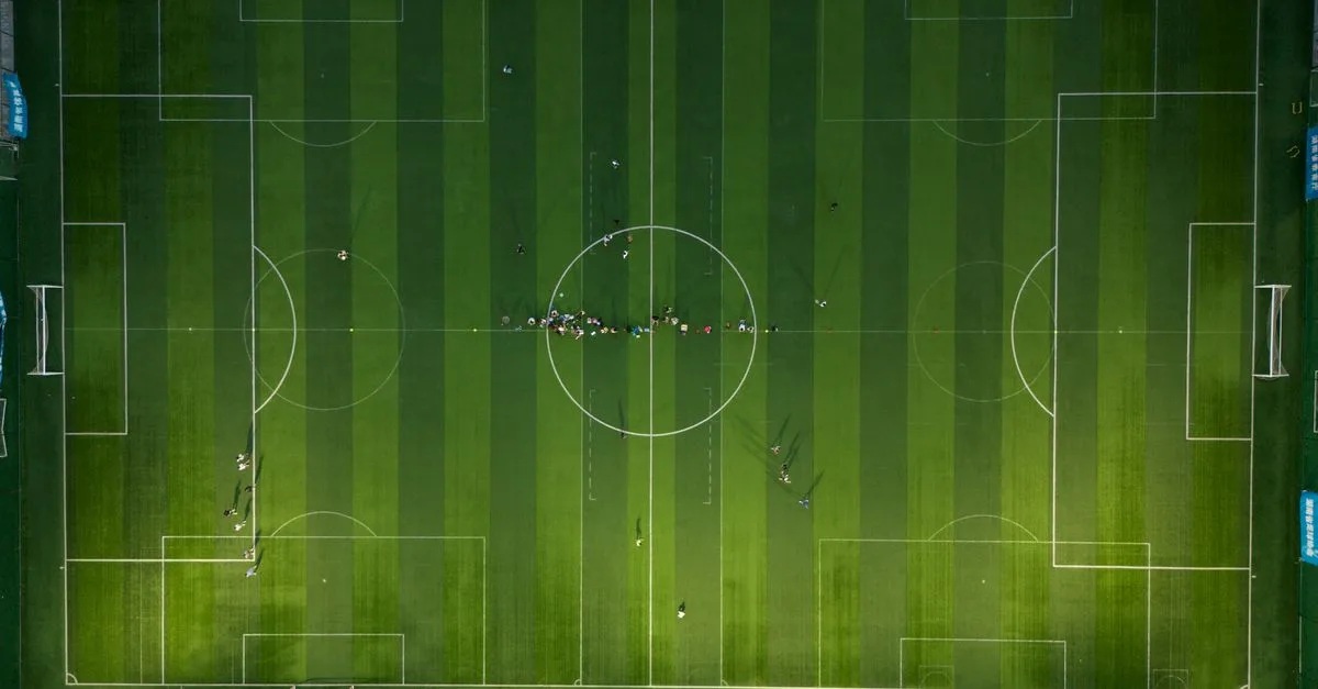 Top-down view of a soccer field with players during daytime.