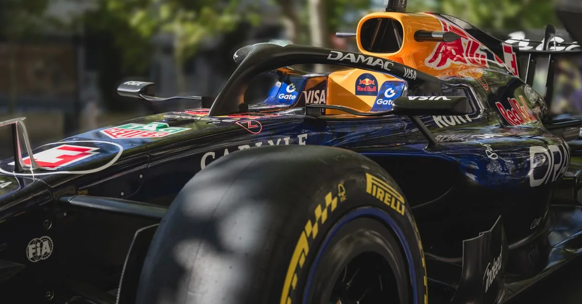 Dynamic shot of a racing car showcasing sleek design and sponsor logos. Perfect for motorsport enthusiasts.