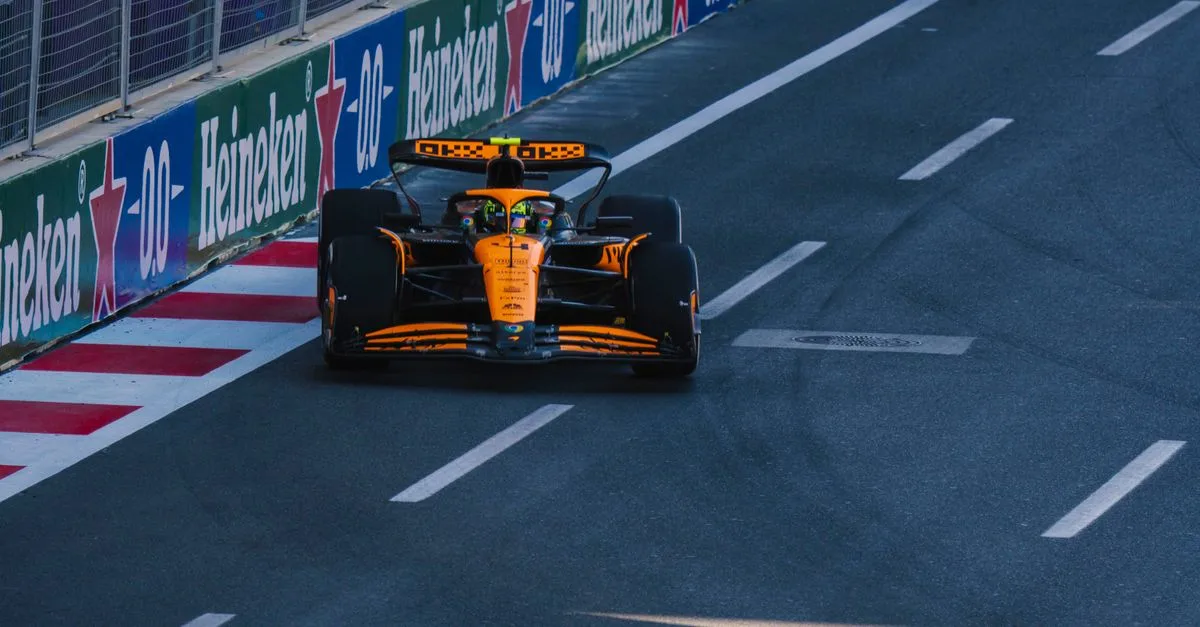 A Formula 1 racing car speeding along the Baku City Circuit during a race event.