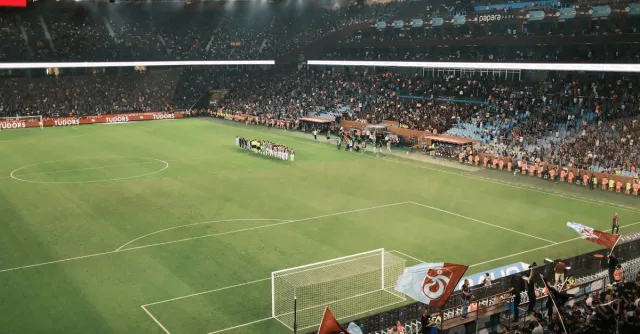 Packed stadium during an exciting night football match with vibrant crowd and field view.
