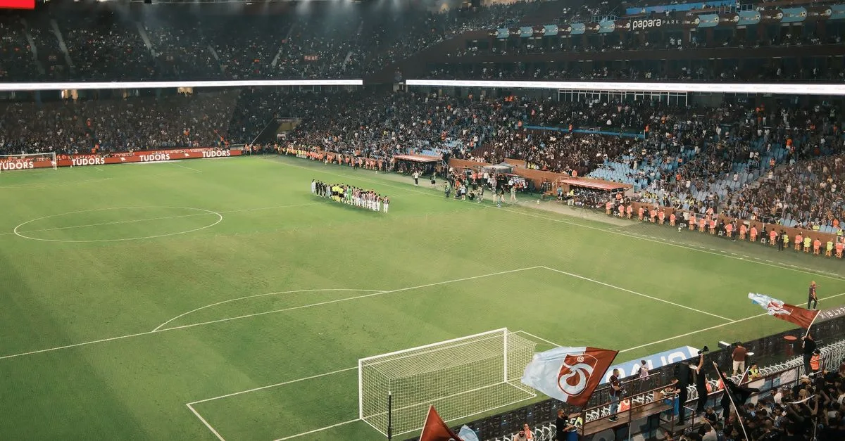 Packed stadium during an exciting night football match with vibrant crowd and field view.
