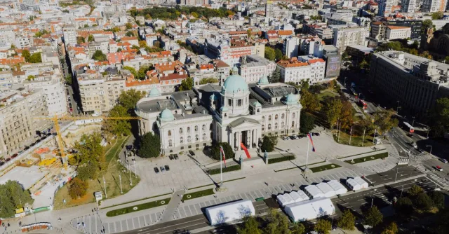 A stunning aerial view of the National Assembly building in Belgrade, Serbia, under clear skies.