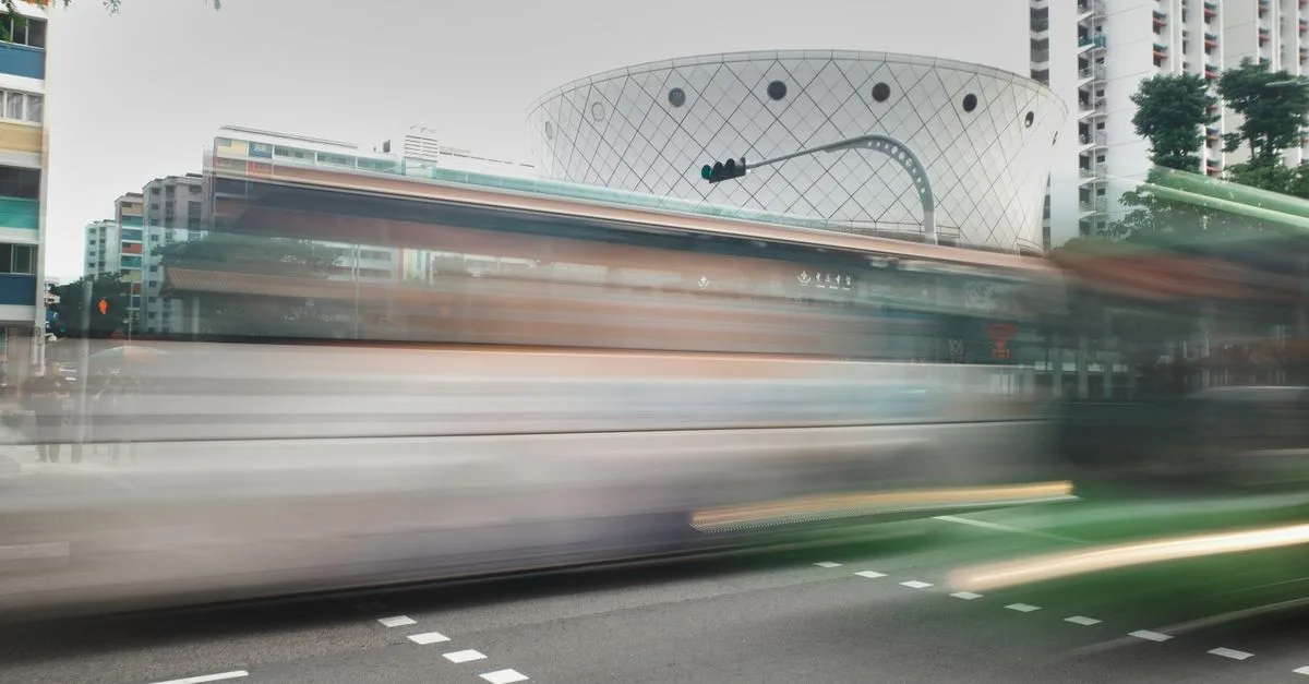 Dynamic urban scene with buses in motion, showcasing city life and architecture.