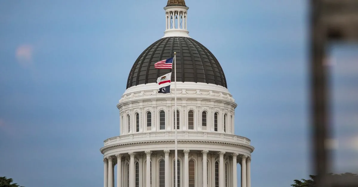 View of California State Capitol dome with American and state flags.