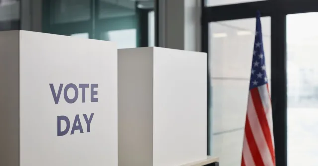 Voting booth setup with American flag, symbolizing election day.