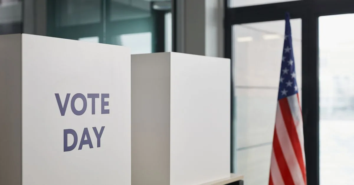 Voting booth setup with American flag, symbolizing election day.