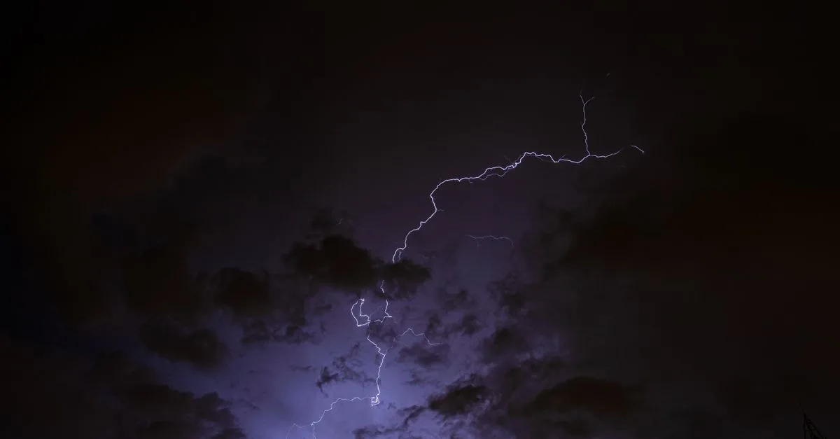A captivating view of lightning striking through a dark, cloudy night sky.