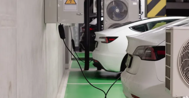 Electric vehicles charging at an indoor station in a modern underground garage.