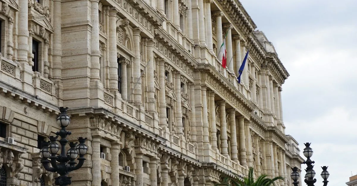 A captivating view of a neoclassical building facade in Rome with Italian flags and detailed architecture.