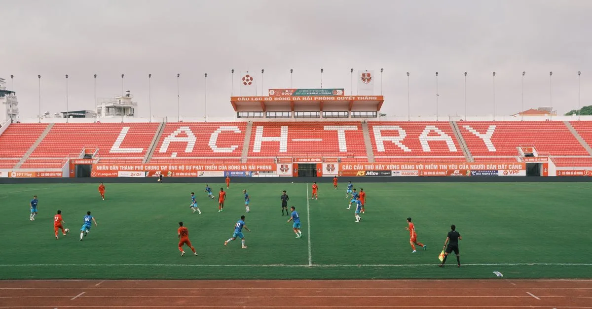 A soccer match underway at Lạch Tray Stadium in Hải Phòng, Vietnam, showcasing vibrant sports action.