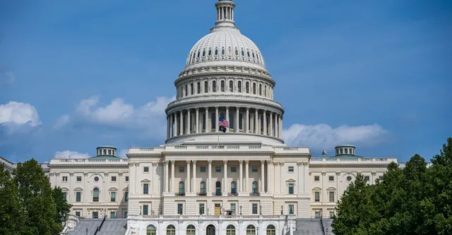 A frontal view of the iconic US Capitol Building in Washington D.C. under blue skies.