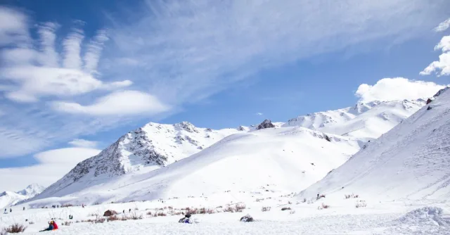 Scenic snow-covered Andes Mountains in Los Penitentes, Argentina, with a vibrant winter sky.
