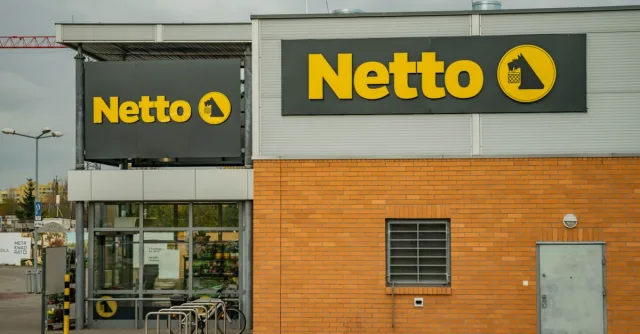 View of Netto supermarket exterior showcasing bold yellow logo signage.