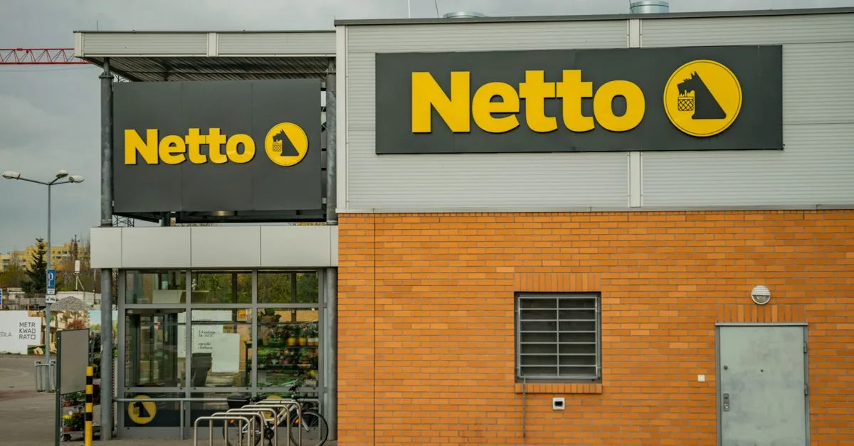 View of Netto supermarket exterior showcasing bold yellow logo signage.