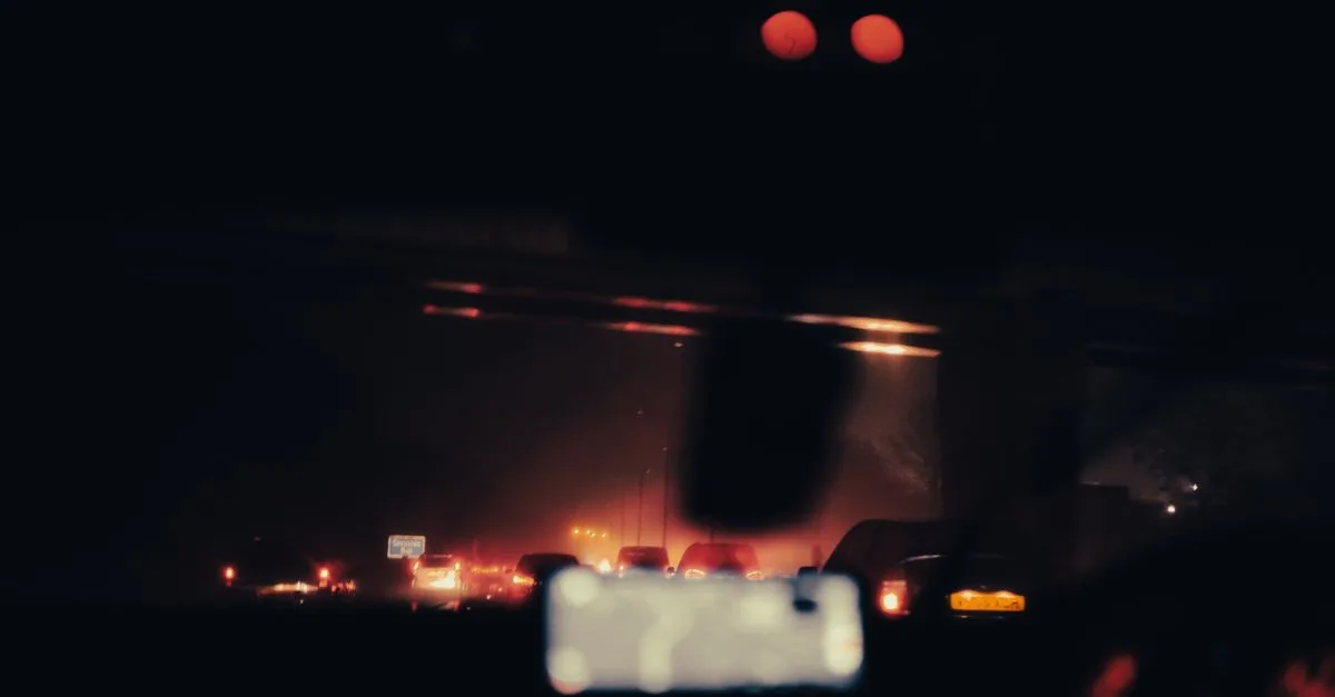 Blurred view of vehicles and car lights on a highway at night, creating a moody and illuminated atmosphere.