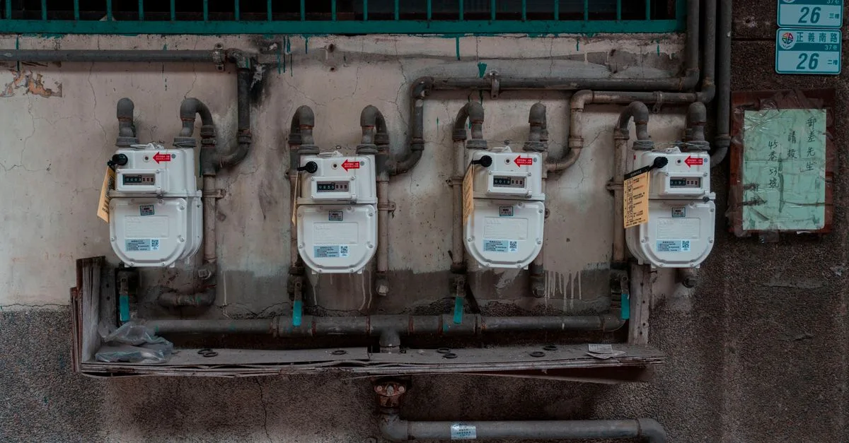 Four gas meters mounted on an exterior wall, showcasing urban utility infrastructure.