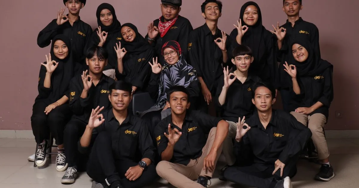 Diverse group of teenagers and a mature woman posing in black outfits, making hand signs.