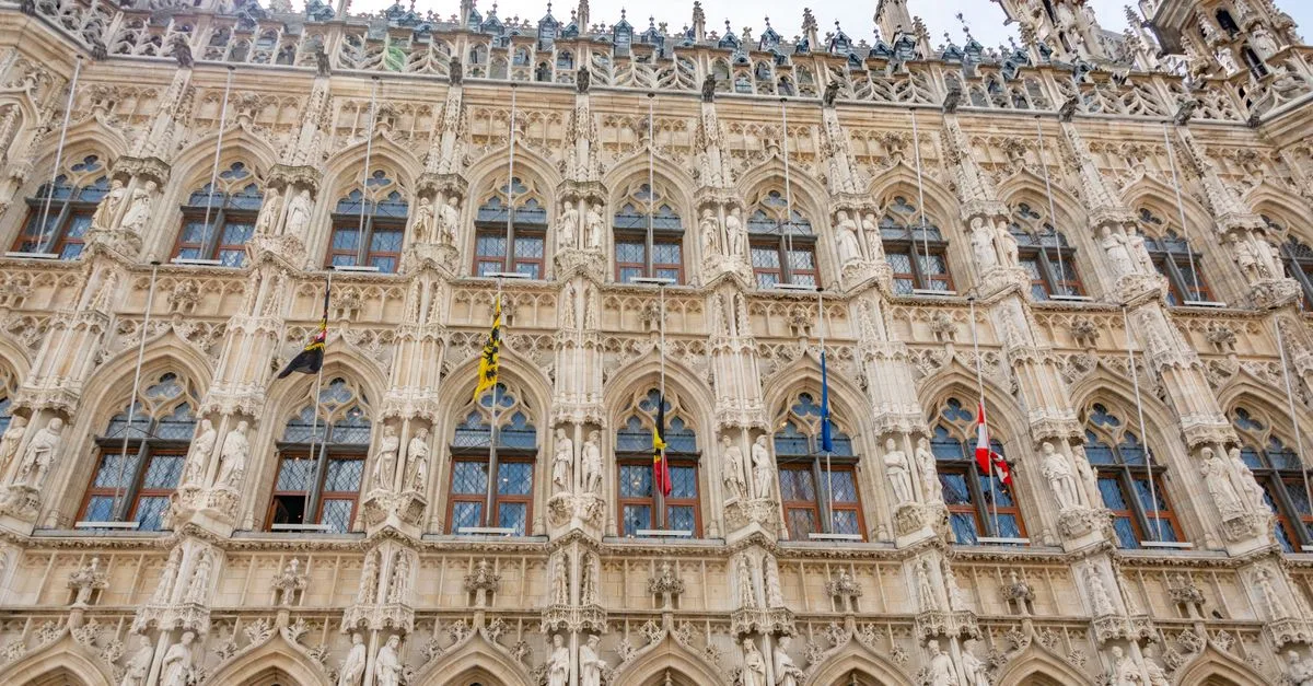 Detailed view of the ornate Gothic facade of Leuven Town Hall, a famous landmark in Belgium.