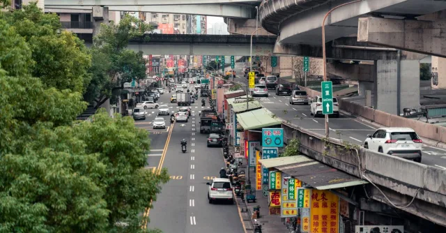 Street view of Taipei showcasing bustling traffic, elevated highways, and vibrant city life.