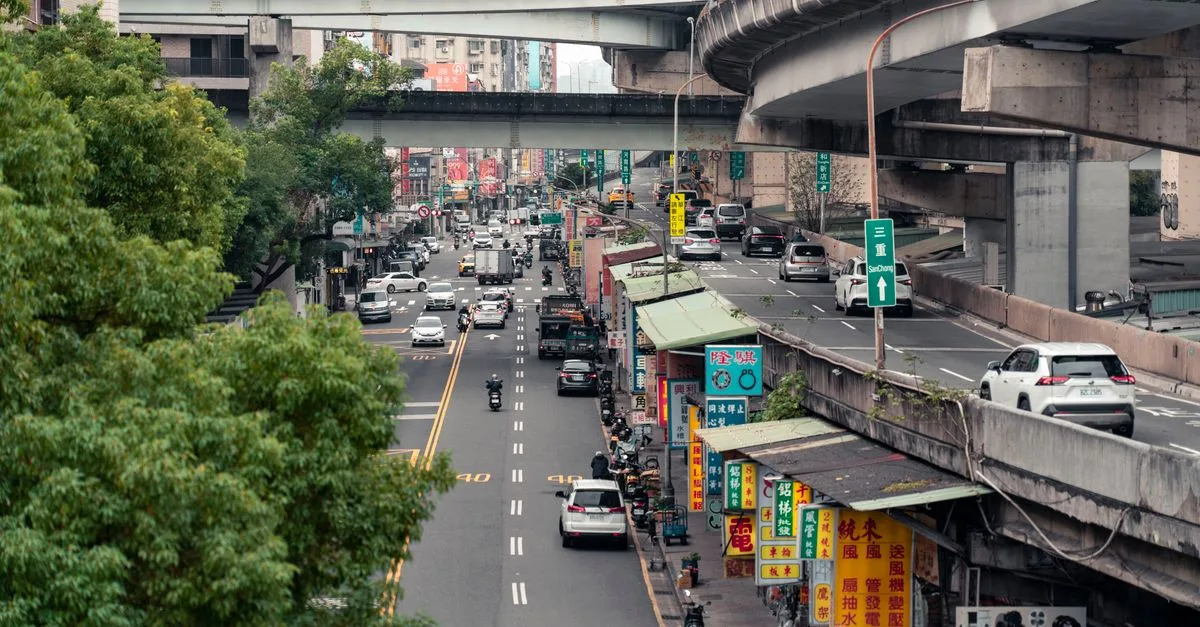 Street view of Taipei showcasing bustling traffic, elevated highways, and vibrant city life.