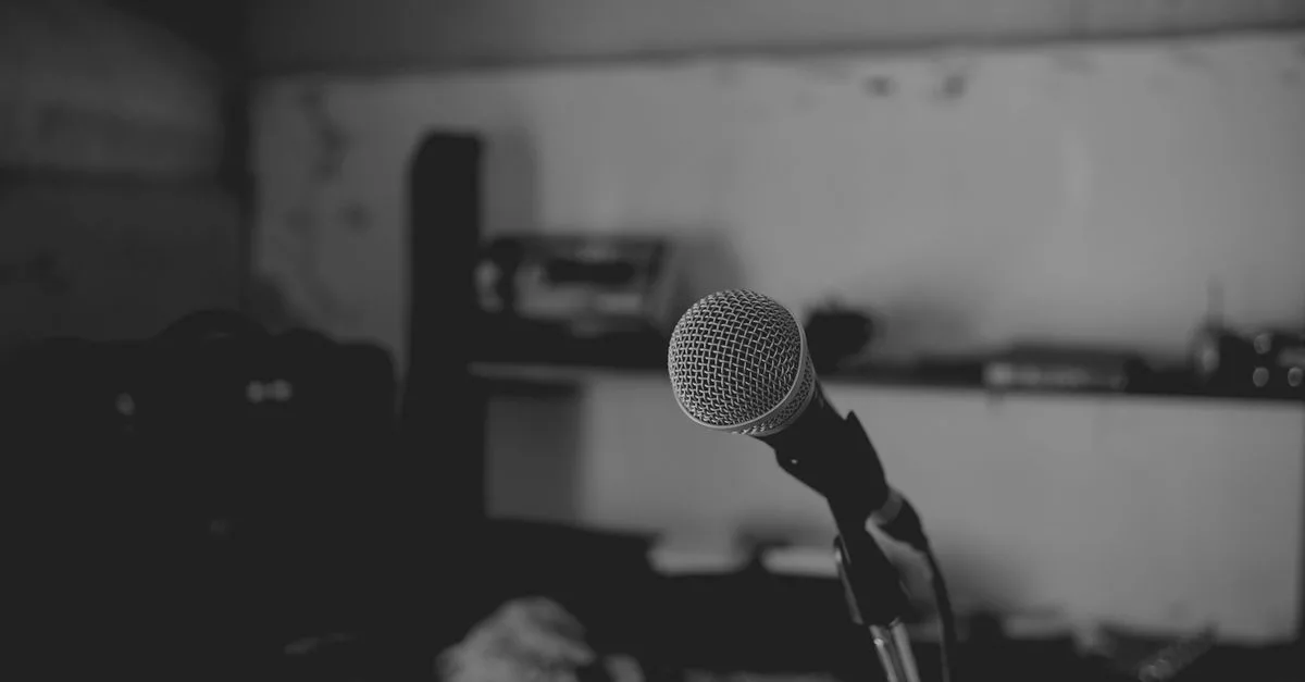 Artistic black and white shot of a music studio with a focus on a microphone. Perfect for music-themed projects.