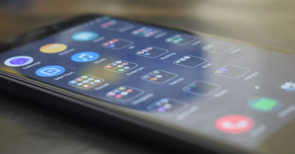 Close-up shot of a smartphone screen showing various app icons, indicating digital technology use.