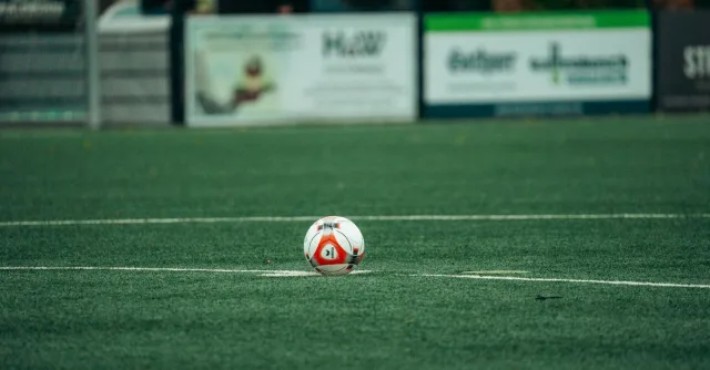 A detailed shot of a soccer ball on a lush green field, perfect for sports-related themes.